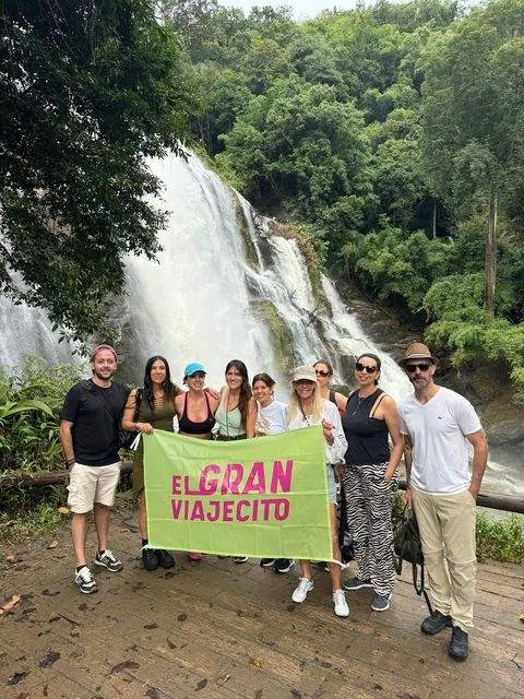 Grupo con bandera en la cascada, Tailandia